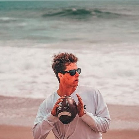 Cade playing football on the beach