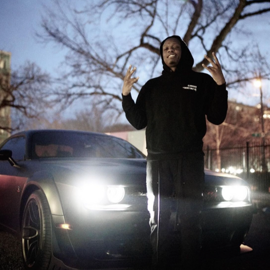 Cassius Winston poses in front of a car